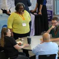 four conference attendees speak at a table