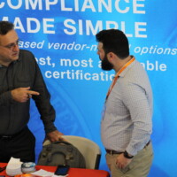 Two men speak at a conference